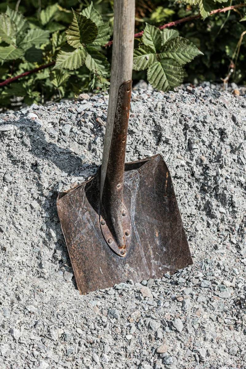 Pelle plantée dans un tas de gravier drainant