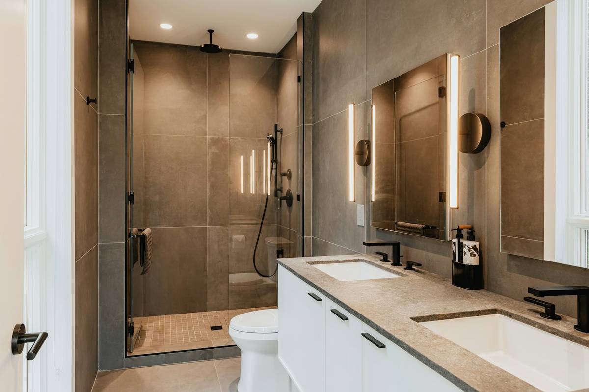 Salle de bains rénovée avec douche vitrée, double vasque et WC suspendu